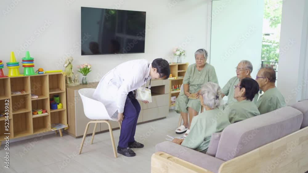 An Asian doctor talking to a group of old elderly patient or pensioner people smiling, relaxing, having fun together in nursing home. Senior lifestyle activity recreation. Retirement. Health care An Asian doctor talking to a group of old elderly patient or pensioner people smiling, relaxing, having fun together in nursing home. Senior lifestyle activity recreation. Retirement. Health care
