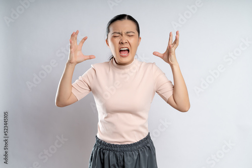 Asian woman angry and shouting isolated on background.