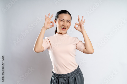 Happy woman showing OK gesture isolated on background.