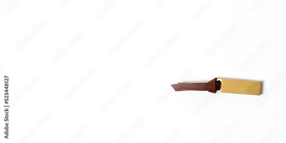 Brass USB blank with leather strap on white background. Copy space. Brass USB blank with leather strap on white background. Copy space.