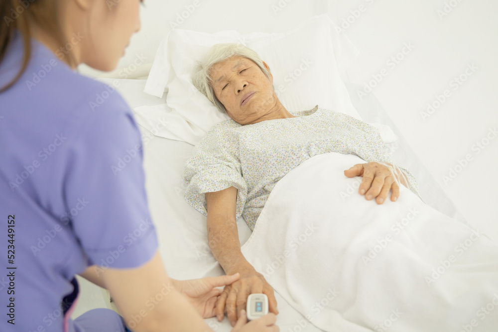 Nurse uses pulse oximeter to measure elderly patient's blood oxygen satuation at home health care Nurse uses pulse oximeter to measure elderly patient's blood oxygen satuation at home health care