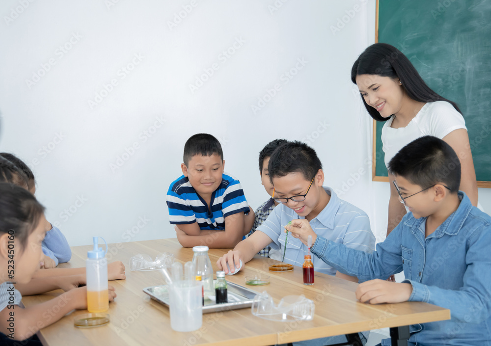 Asian students learning to experimentation with female teacher in classroom, education concept Asian students learning to experimentation with female teacher in classroom, education concept