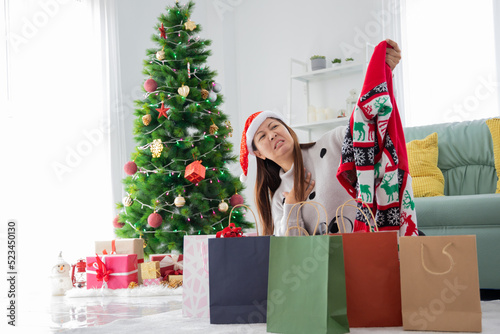 asian woman received a terrible present from online shopping, grumpy girl in santa hat buying clothes from christmas sale