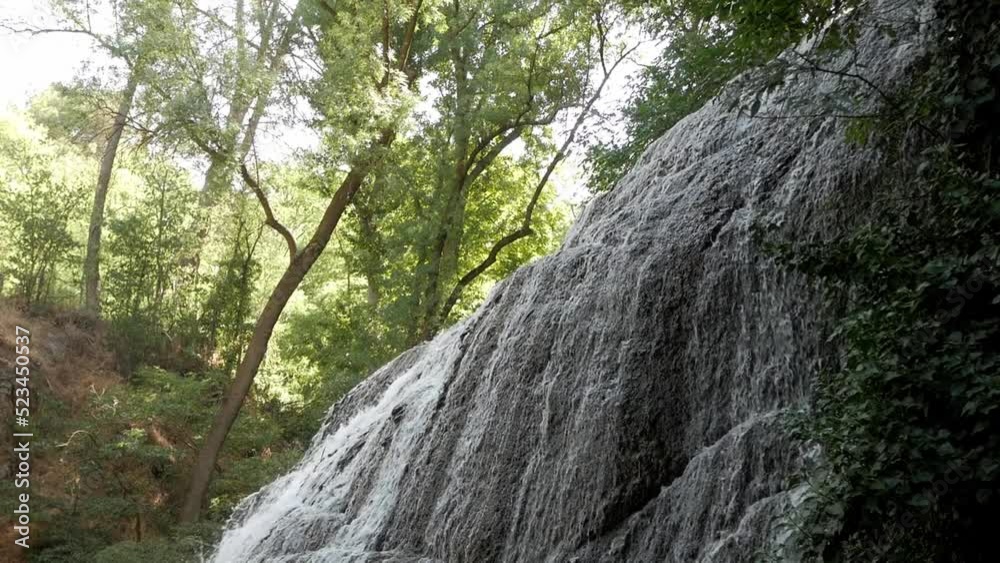 Beautiful cascade on rock wall formation in forest scenery. Thin water stream cover's the rock. Vegetation to the sides and tall trees. Sunny day. Stunning nature landscape. Monasterio de Piedra,Spain Beautiful cascade on rock wall formation in forest scenery. Thin water stream cover's the rock. Vegetation to the sides and tall trees. Sunny day. Stunning nature landscape. Monasterio de Piedra,Spain