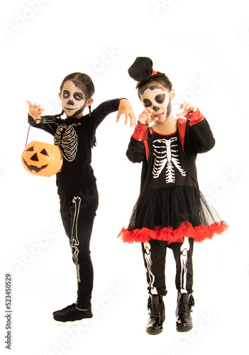  two asian little girls wearing halloween costume standing over white background