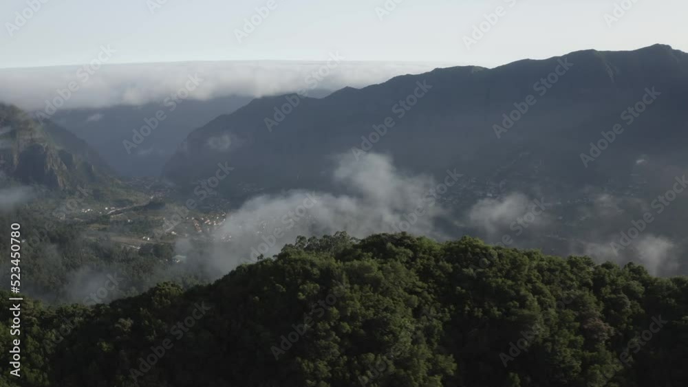 Drone shot over the peaks and valleys in Madeira with thin clouds floating above. Drone shot over the peaks and valleys in Madeira with thin clouds floating above.