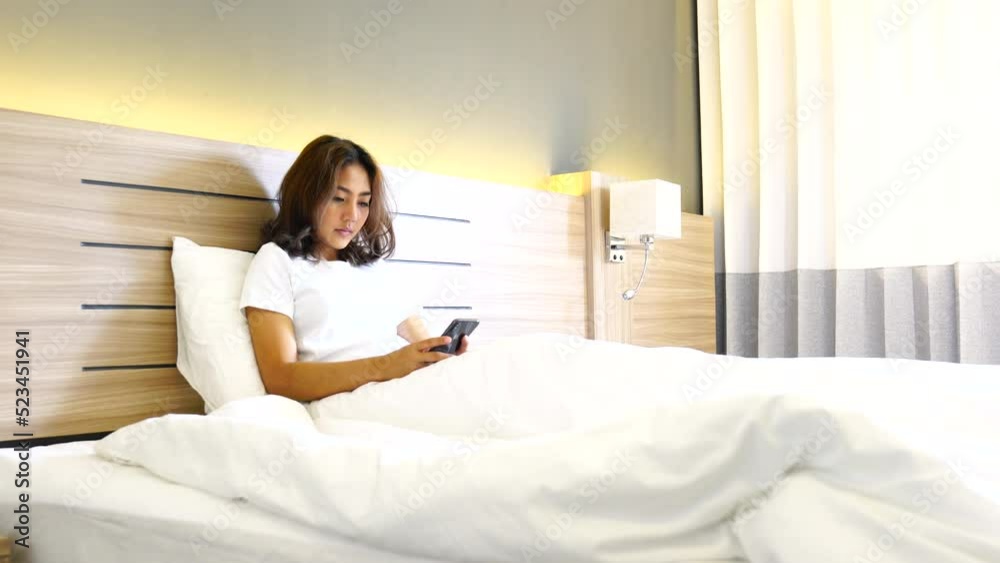 women use smartphone for shopping online, Relax, watch series on the bed room women use smartphone for shopping online, Relax, watch series on the bed room