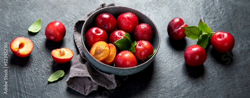 Fresh red plums in plate.