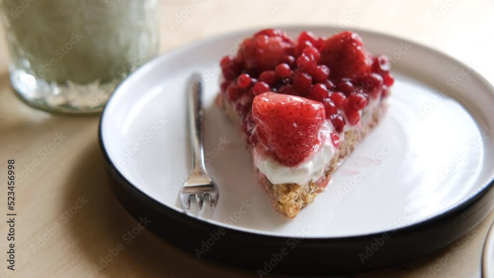 Closeup shot of tasty healthy fresh berry pie at cafeteria and matcha latte, camera tilting up. Healthy eating and lifestyle concept Closeup shot of tasty healthy fresh berry pie at cafeteria and matcha latte, camera tilting up. Healthy eating and lifestyle concept
