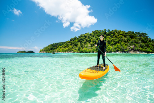 Asian woman relax on the beach with SUP BOARD