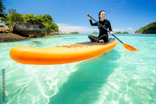 Asian woman relax on the beach with SUP BOARD photo