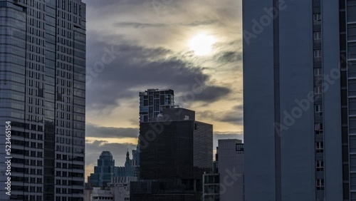 Time lapse view of Bangkok cityscape with high-rise buildings and BTS skytrains with moving clouds photo