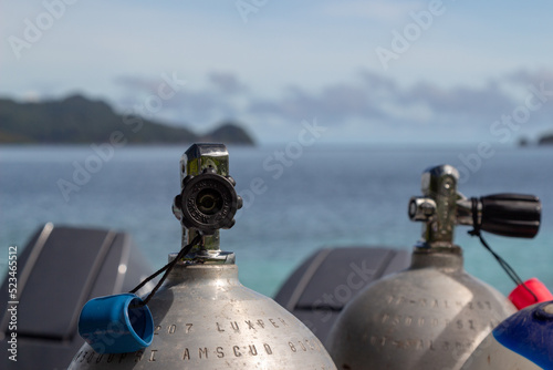 Scuba tanks with valves with the sea in the background