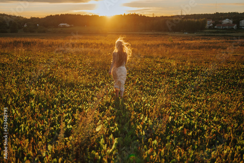 young woman walking in the countryside sunset