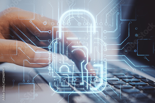 Close up of businessman hands using laptop computer with creative glowing padlock circuit security hologram on blurry background. Safety and web protection concept. Double exposure.