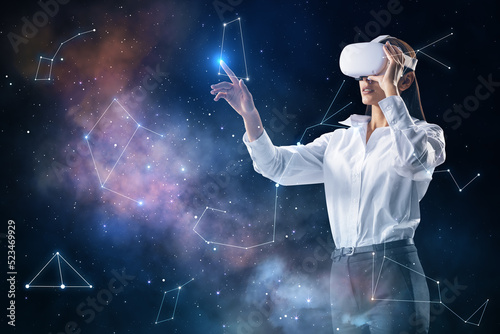 Thoughtful young european woman with VR glasses on dark night sky background with polygonal constellations. Cosmos, augmented reality, metaverse and space concept. © Who is Danny
