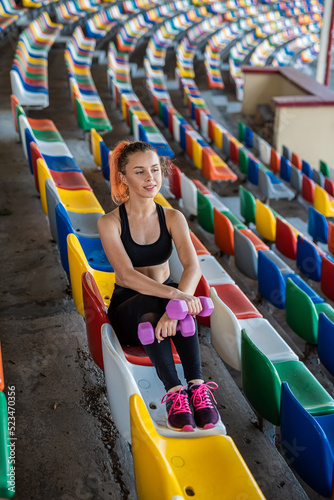 Wallpaper Mural female trainer doing exercises with dumbbells on stadium chairs Torontodigital.ca