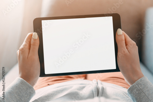 Young woman resting on sofa with digital tablet with place for text on screen. Point of view.