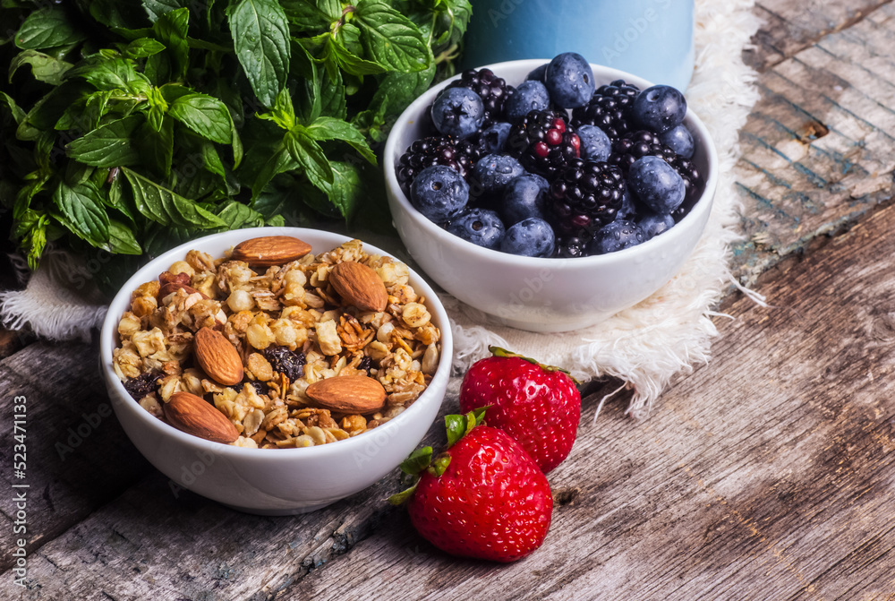 Healthy breakfast with granola, nuts and berries.