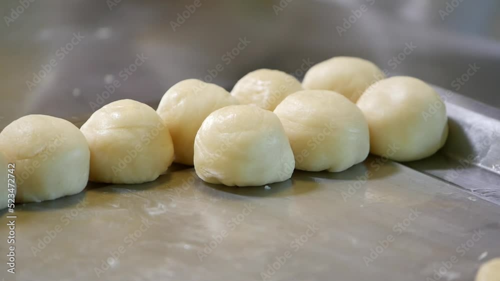 Unbaked Chinese Pastry On Tray With Hand Kneading Dough In Background, Close Up Unbaked Chinese Pastry On Tray With Hand Kneading Dough In Background, Close Up