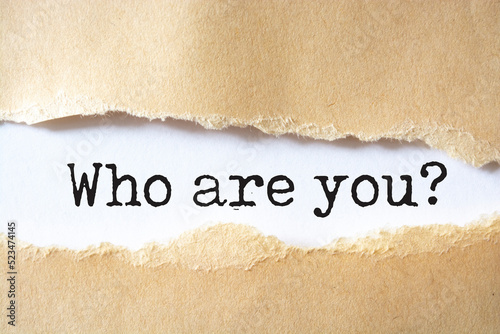 Who are you? question written under torn paper.