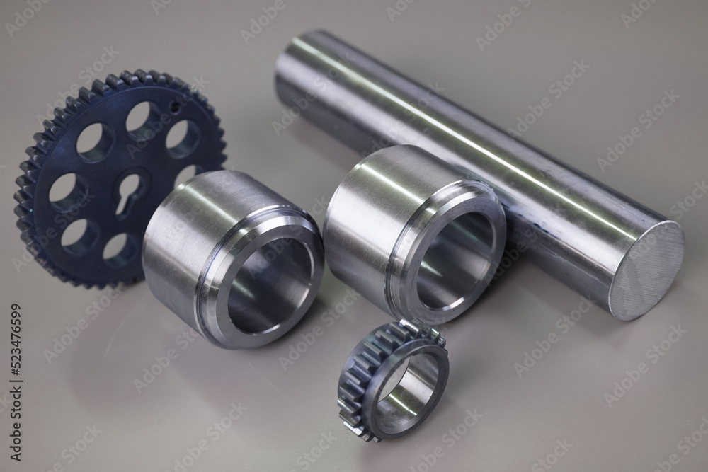 Steel turning and milling parts and gears on a dark background. Metal production Steel turning and milling parts and gears on a dark background. Metal production