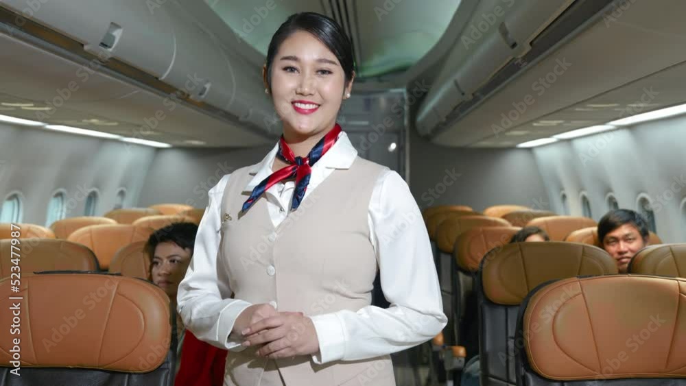 Asian beautiful charming stewardess safety in uniform standinf cross hands in airplane, air hostess smiling cabin crew inside aircraft passenger seat, Airline transportation and tourism concept
