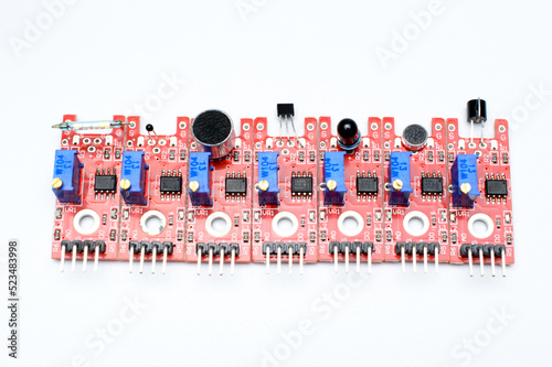 Arduino DIY modules on a white background. Selective focus. Red PCB. Blue potentiometers. Technological concept. Top view. photo