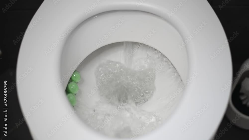 Small piece of toilet paper flushed down a white toilet. Static frontal view Small piece of toilet paper flushed down a white toilet. Static frontal view