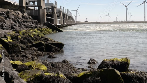 Wallpaper Mural close up of the shore of the north sea with the strong current at the delta works in the netherlands a windmill field in the background Torontodigital.ca