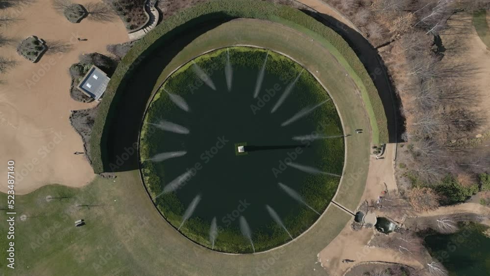 Stunning view of a water fountain feature in a private garden. Aerial top down elevating revealing rise up shot. Stunning view of a water fountain feature in a private garden. Aerial top down elevating revealing rise up shot.