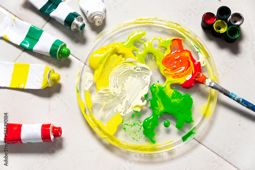 tubes of paint next to brush and color palette 