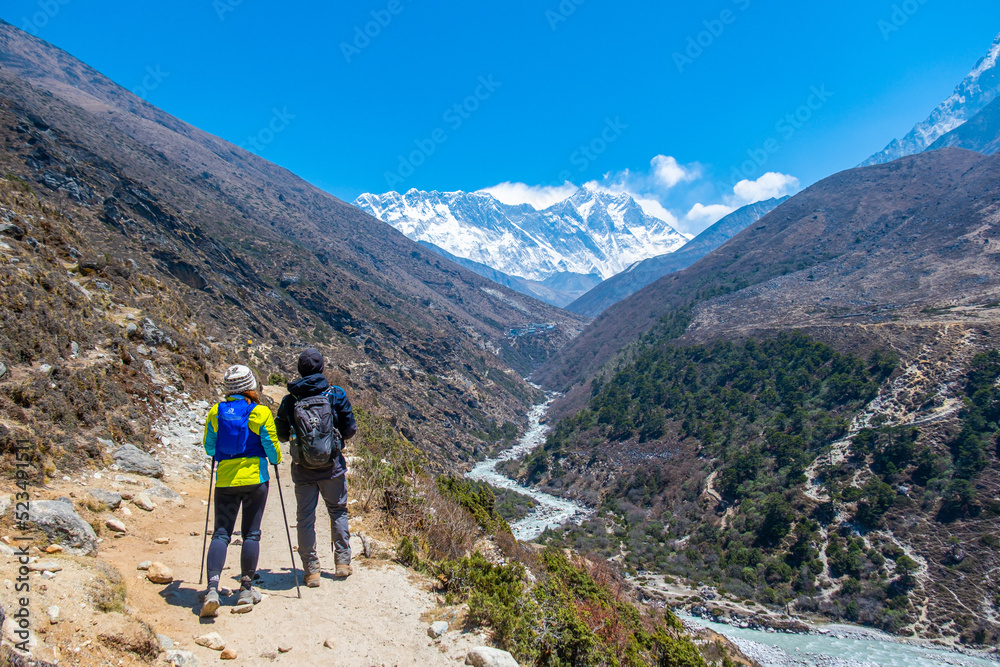 A group of people trekking on dirt road in Nepal to Everest Base Camp