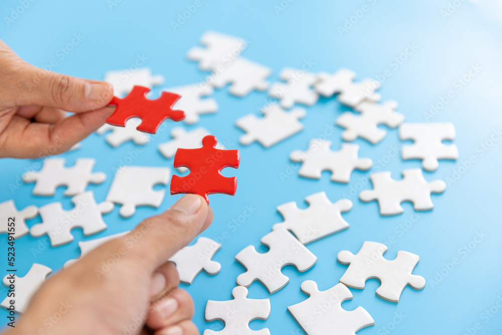 Hand of woman connecting jigsaw puzzle, Business solutions, success and strategy, Business partnership concept. Hand of woman connecting jigsaw puzzle, Business solutions, success and strategy, Business partnership concept.