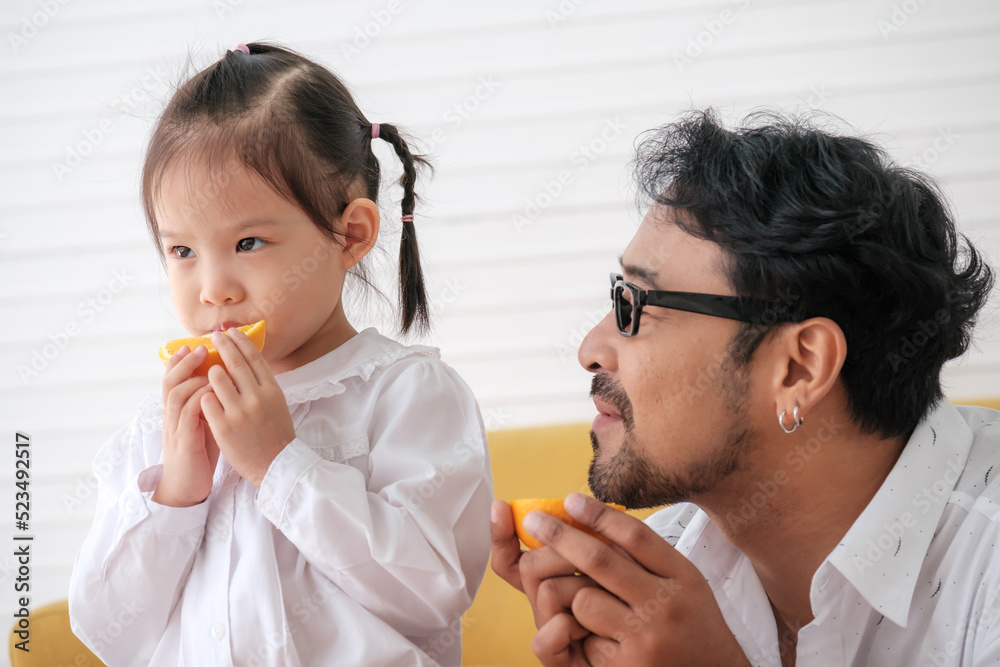 Father teaches kids to eat fruits and is glad that kids eat fruits. Father teaches kids to eat fruits and is glad that kids eat fruits.