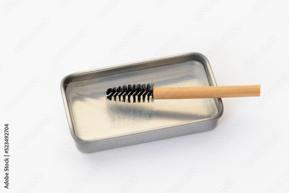 Eyebrow brush made of bamboo and transparent soap for styling eyebrows in metal packaging. Cosmetic set isolated on white background Eyebrow brush made of bamboo and transparent soap for styling eyebrows in metal packaging. Cosmetic set isolated on white background