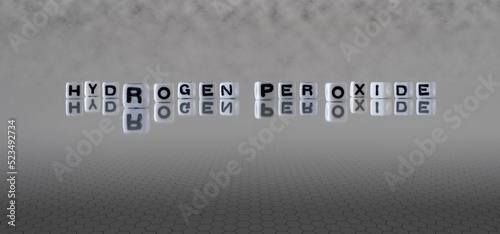 hydrogen peroxide word or concept represented by black and white letter cubes on a grey horizon background stretching to infinity photo