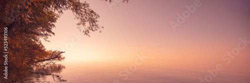 Lake in the early foggy morning. Sunrise over the lake. Beautiful morning landscape
