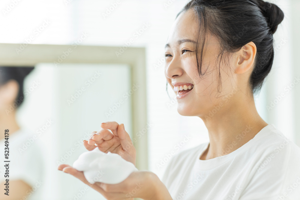 洗顔の泡を手に乗せる若い女性