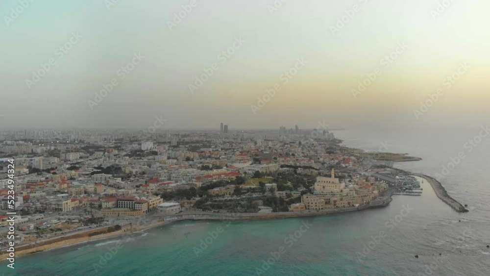 Aerial view at a very high altitude of the old port of Jaffa above the sea, at sunset with a slow and calm flight Aerial view at a very high altitude of the old port of Jaffa above the sea, at sunset with a slow and calm flight