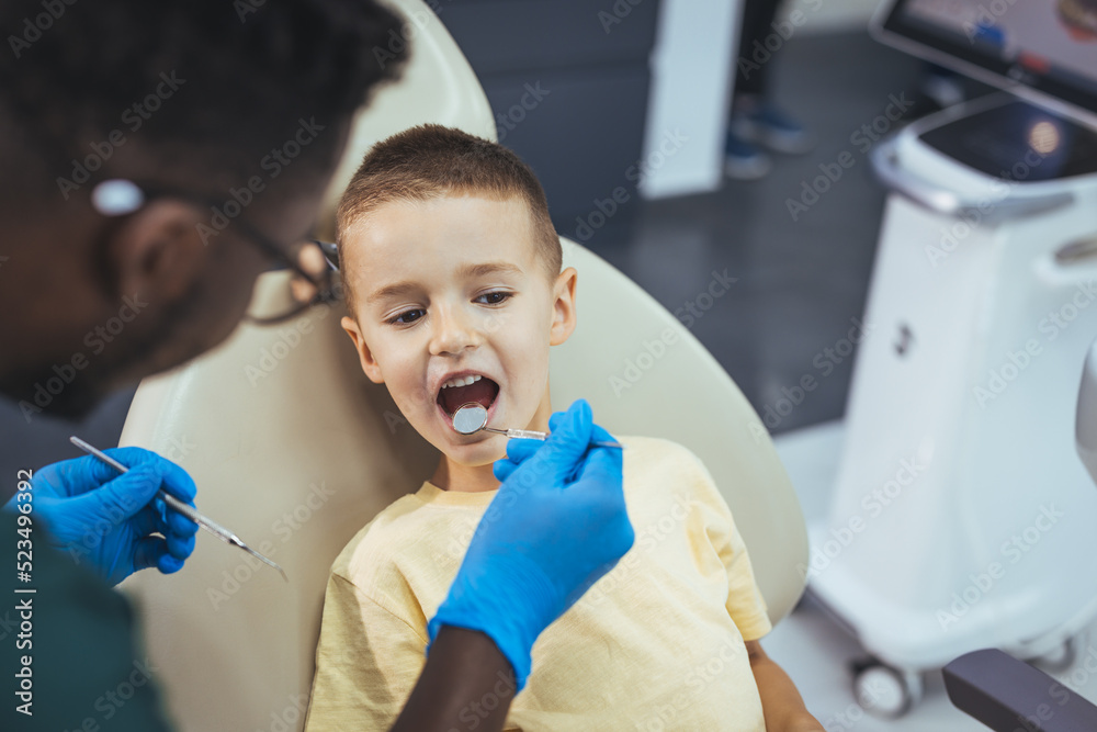 Shot of a young little boy lying down on a dentist chair while getting