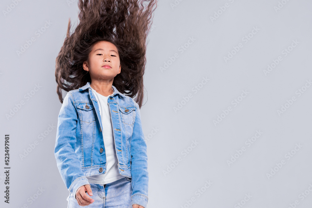 Cute girl child with beautiful long flying hair on a light background in studio Cute girl child with beautiful long flying hair on a light background in studio