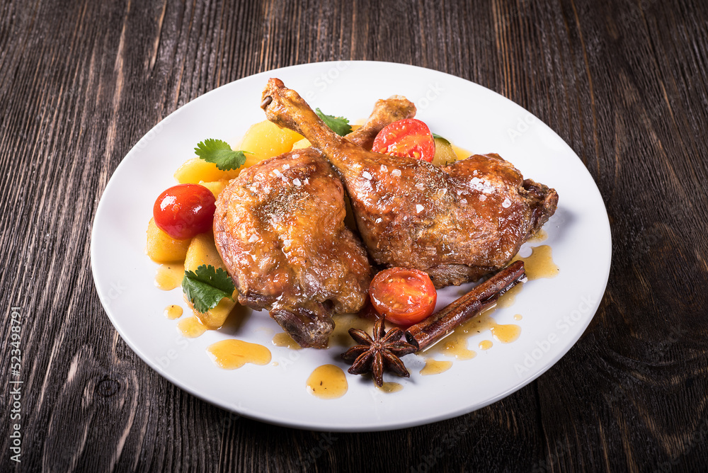 Duck legs with apples in orange sauce on a wooden background Duck legs with apples in orange sauce on a wooden background