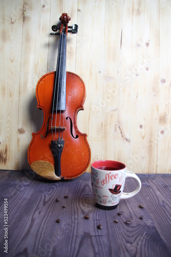 still life of cup of coffee and violin on wooden background