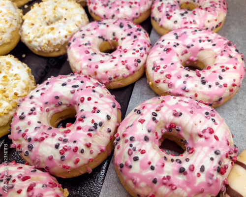 Assorted pink donuts in bakery shop