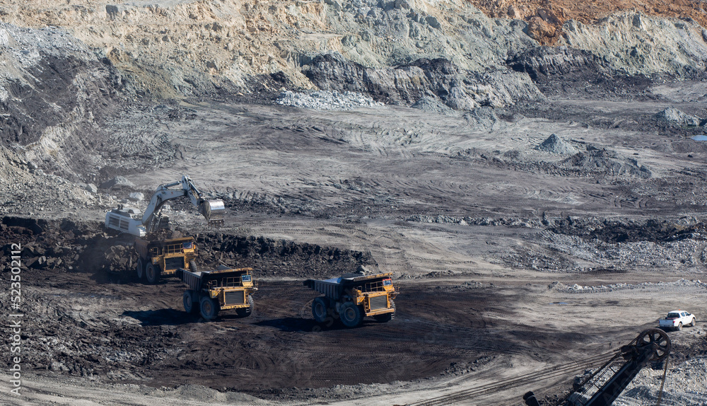 Panoramic aerial view of coal mine. Open pit mine industry, big yellow mining truck for coal quarry. Open coal mining anthracite mining. Pit on coal mining by open way. Panoramic aerial view of coal mine. Open pit mine industry, big yellow mining truck for coal quarry. Open coal mining anthracite mining. Pit on coal mining by open way.
