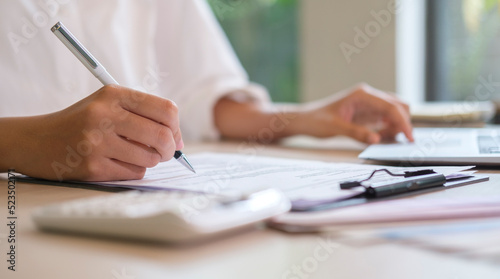 Professional female accountant working with financial statistics graphs at office desk..