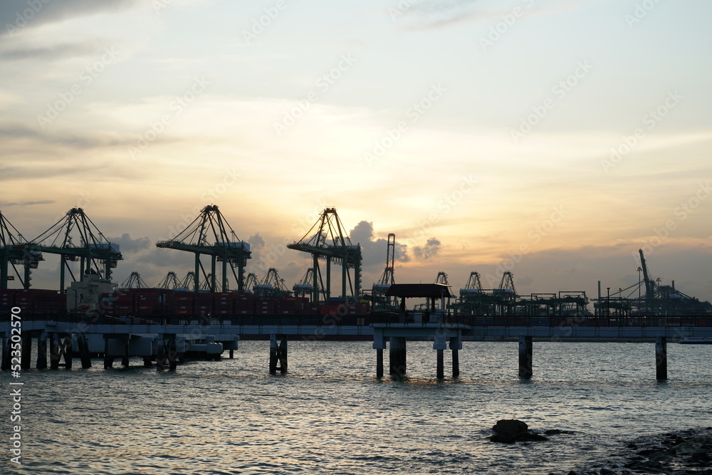 sunset at the pier Trading seaport with cranes, cargoes and the ship harbour or port and container terminal sunset the seaside park Singapore