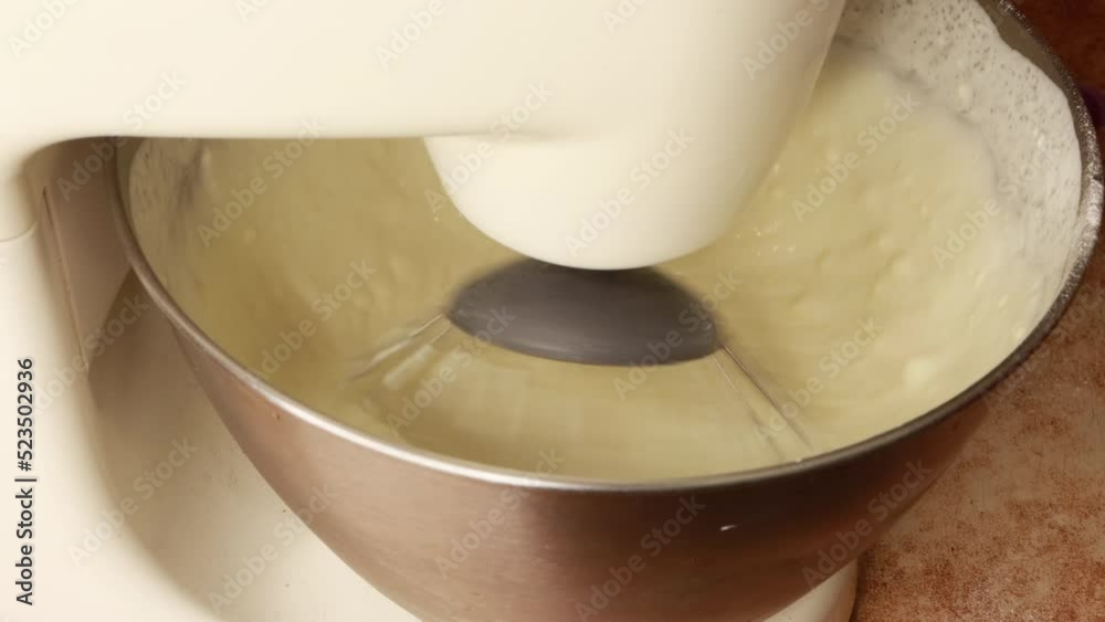 food processor whips white cream in the bowl of a food processor close-up with a plastic lid on the bowl food processor whips white cream in the bowl of a food processor close-up with a plastic lid on the bowl