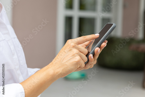 female hands hold a modern mobile phone on the street..education, modern app, shopping order, work online